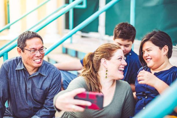 妈妈用手机在户外为她的多种族家庭自拍图片下载