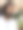 特写照片:一个印度人喝着一杯加冰、薄荷叶和柠檬片的莫吉托鸡尾酒，通过吸管，坐在沙滩餐厅的酒吧里，看着镜头，坐在遮阳伞下，聚焦于前景图片下载