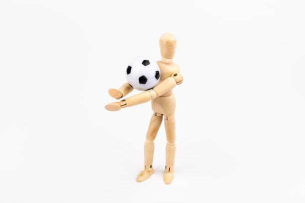 木制假人与足球孤立在白色背景。足球运动员的概念。图片下载