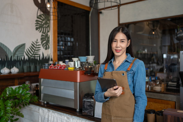 在咖啡店工作的亚洲年轻女子。小企业，企业主。图片下载