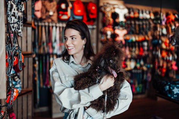 宠物店里有个带着贵宾犬的年轻女人图片下载