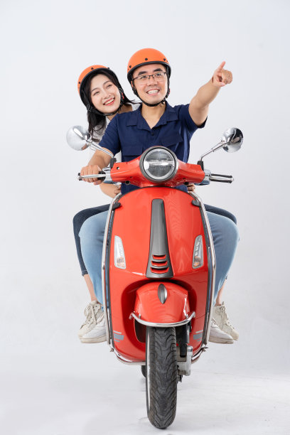 亚洲夫妇在白色背景上骑滑板车图片下载