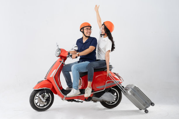 亚洲夫妇在白色背景上骑滑板车图片下载