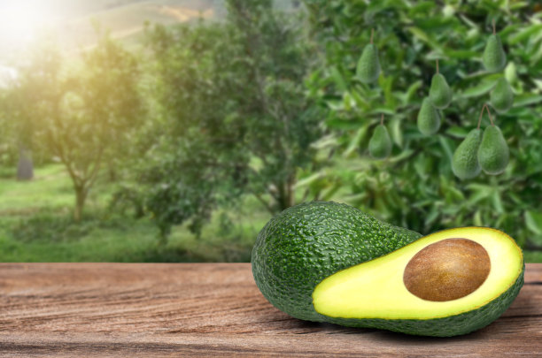 牛油果切半块放在木桌上图片下载
