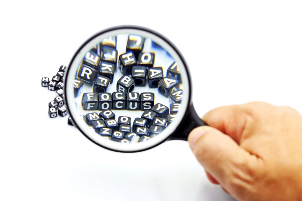 有选择性的重点。一只拿着放大镜的手正盯着FOCUS这个词图片下载