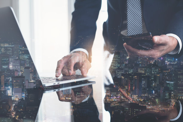 商人在笔记本电脑和智能手机上工作的双重曝光图片下载