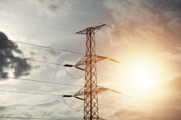 夕阳背景下的高压电塔。电线对着天空图片下载