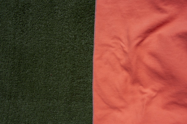 草地上一条橙色毛巾的特写图片下载