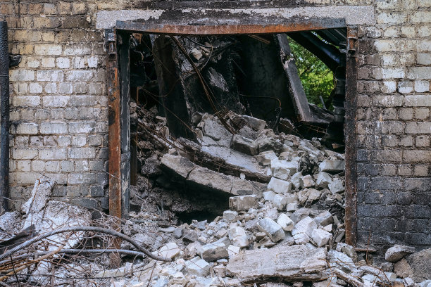 一座工业建筑的砖墙和钢筋混凝土屋顶结构的门口在火灾后倒塌。图片下载