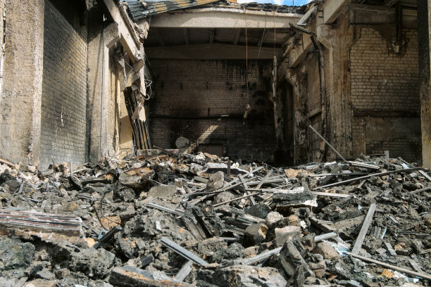 一座工业建筑的钢筋混凝土屋顶结构和屋顶金属板在火灾后倒塌。一堆建筑残骸。图片下载