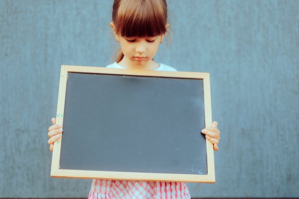 蹒跚学步的小女孩拿着黑板为拷贝空间图片下载