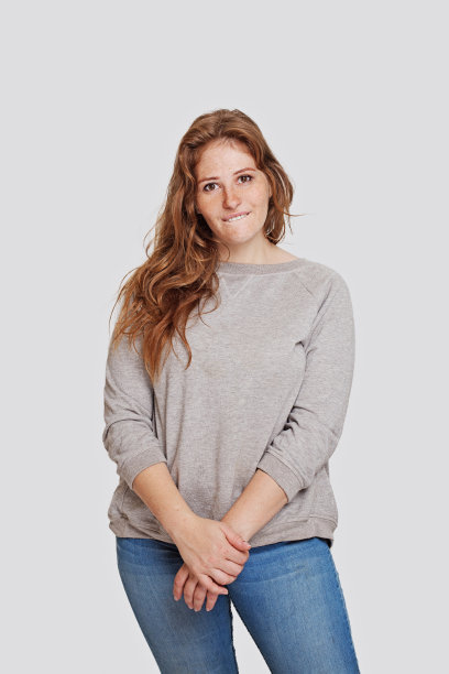 有趣的女人穿着休闲服站在白色的墙壁背景，工作室的肖像图片下载