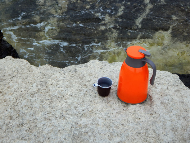 岸边的橙色保温瓶。图片下载
