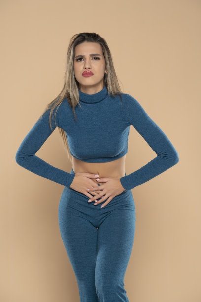 特写女人抱着肚子，感觉不舒服，健康问题的概念，不开心的女孩站在米色背景，胃痛，食物中毒，胃炎，腹痛，月经期图片下载