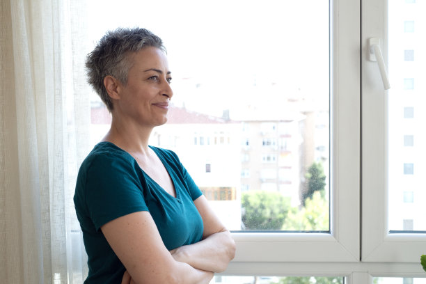 美丽的成熟女人在窗边放松的肖像图片下载