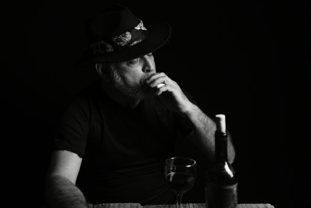 坐着喝酒的男子脸上表情黑白照片配剪影图片下载