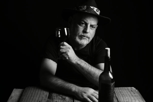 坐着喝酒的男子脸上表情黑白照片配剪影图片下载