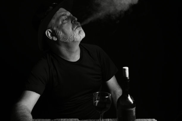 坐着喝酒的男子脸上表情黑白照片配剪影图片下载