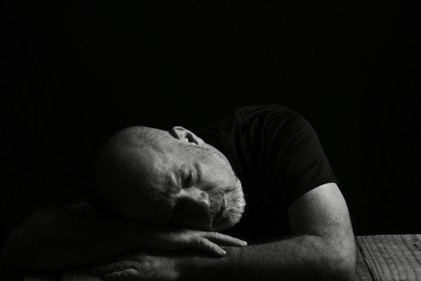 坐着喝酒的男子脸上表情黑白照片配剪影图片下载