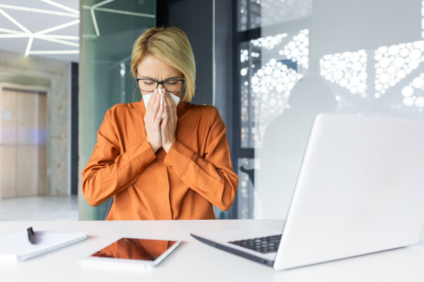 职场生病女性在办公室工作，商务女性在工作时过敏、打喷嚏、流鼻涕、感冒图片下载