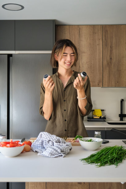 亚洲年轻人在厨房检查配方香料。图片下载