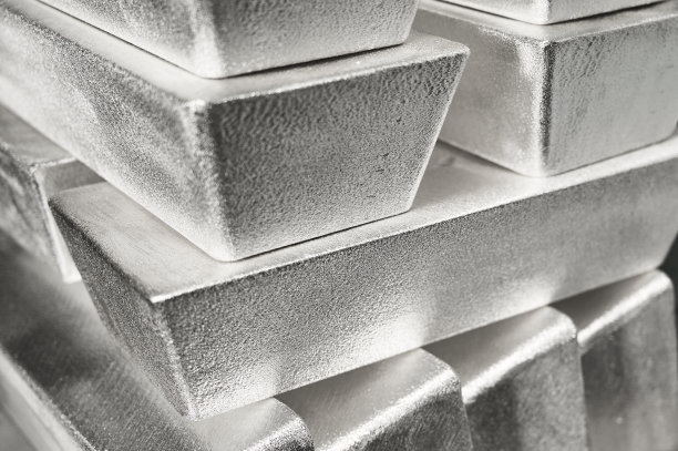 仓库中明亮光线下堆叠的工业银锭图片下载