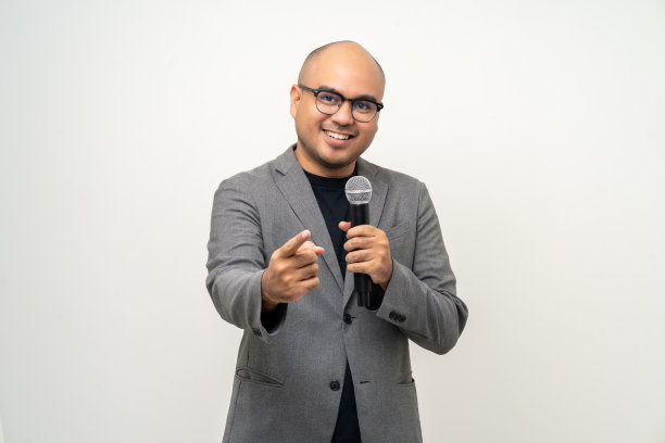 配有高质量动态麦克风的商人扬声器，在孤立的白色背景上与人交谈。男性为面试测试麦克风声音。激励生活教练在培训图片下载