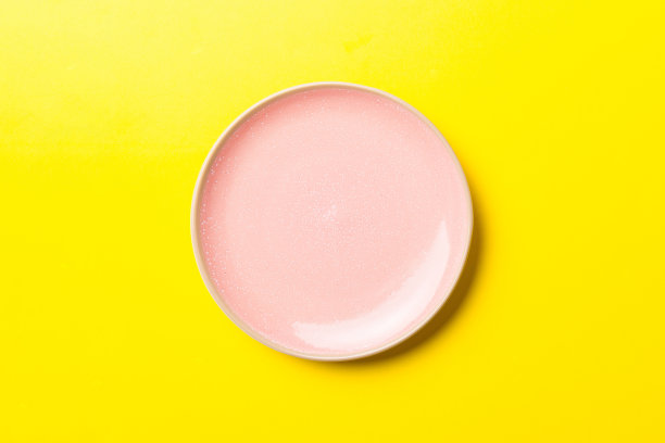 俯视图孤立的彩色背景空圆形粉红色盘子的食物。空盘子，为你的设计留出空间图片下载