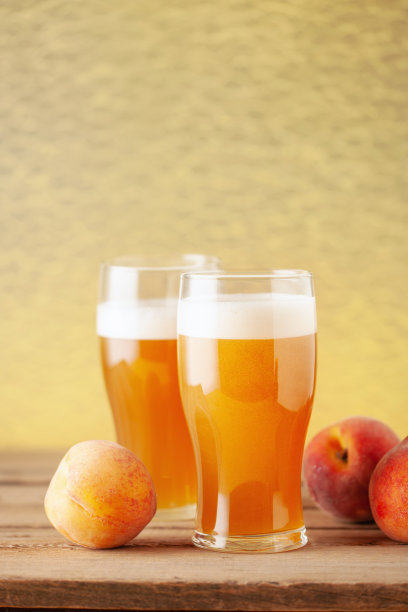 在木桌上的一品脱玻璃杯里有清凉的冷硬桃子苹果酒或精酿水果啤酒。本空间图片下载