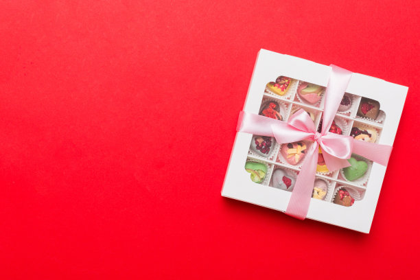 盒装巧克力糖果，彩色背景，各种糖果。情人节礼盒。顶视图平面布局与复制空间图片下载