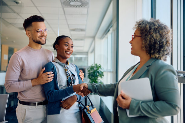 幸福的夫妇在办公室成功会面后与他们的理财顾问握手。图片下载