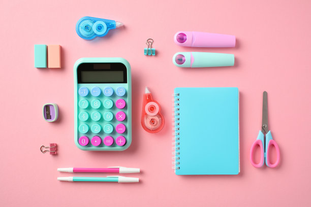 回到学校的概念。淡粉色背景的学习用品。平铺，俯视图计算器，纸质笔记本，剪刀，钢笔，卷笔刀，橡皮，记号笔图片下载