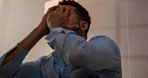 一个商人坐在地板上，因为生活中的问题而感到沮丧和压力。图片下载