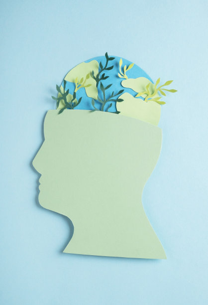 头部剪影由纸和行星地球模型与绿色植物。环境与生态关怀图片下载