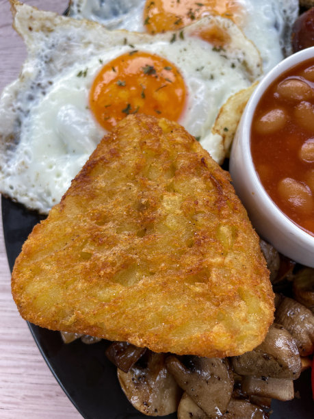 全画幅图片黑色盘子全英式油炸早餐食材，烤豆包围香肠，蘑菇，刺眼的棕色，单面煎蛋，高架视图图片下载