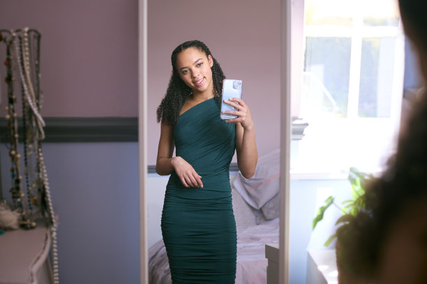 十几岁的女孩在家里的卧室准备毕业舞会或晚上出去在镜子里自拍图片下载