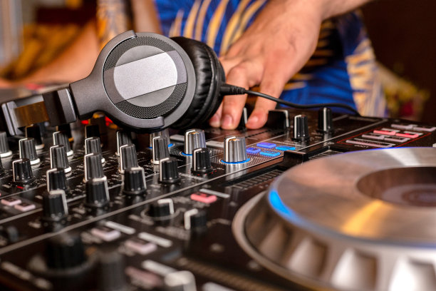 DJ手创建和播放音乐的DJ控制台混频器在一个音乐会派对，夜总会，特写视图图片下载