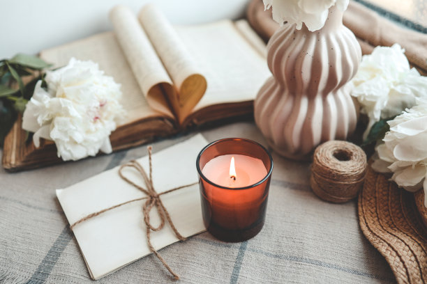 惬意的春天构图，燃烧的蜡烛，牡丹和帽子图片下载