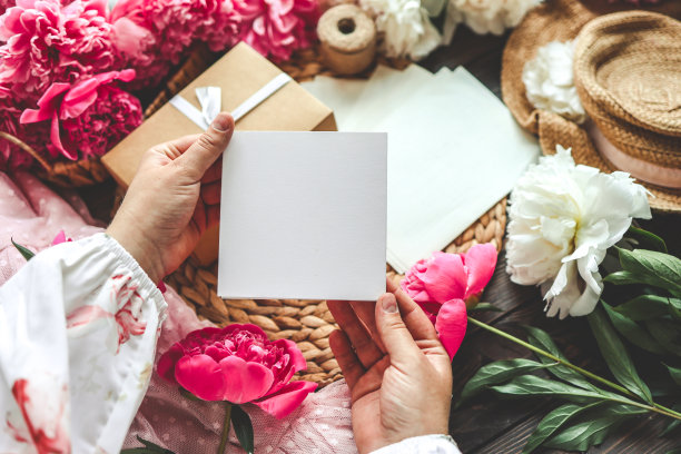 女人的手拿着一封装在手工信封里的信。粉红色的背景，母亲节的概念。放文字的地方图片下载