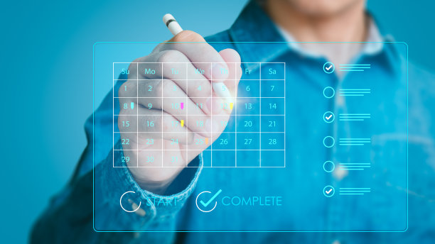 他的右手在一个数字平板电脑上为日历和组织者的议程创建了一个约会提醒。活动策划者利用时间表来安排活动。图片下载