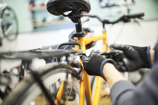 修理自行车:一个人在他的车间里拆卸一辆橙色的自行车图片下载