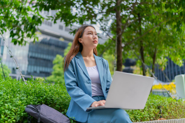 自然的办公室。亚洲女商人在公园用笔记本电脑赚钱。走出家门。混合动力工作图片下载