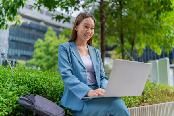 自然的办公室。亚洲女商人在公园用笔记本电脑赚钱。走出家门。混合动力工作图片下载