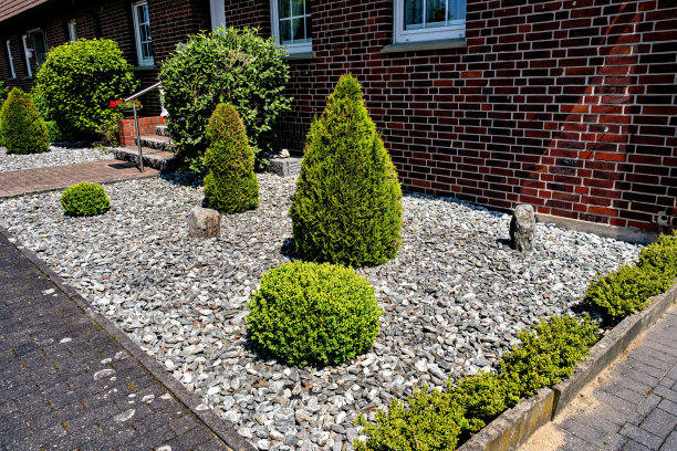 德国一座砖房附近的灌木和石头的美丽装饰景观设计图片下载