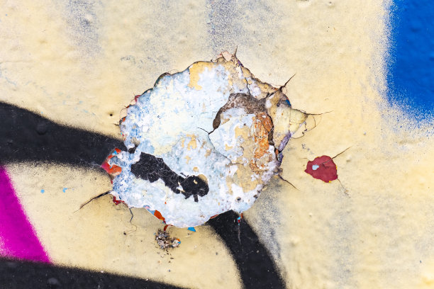旧墙的彩色裂缝和碎片的特写。图片下载