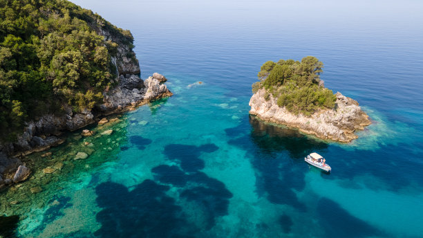 上面的图片是地中海的一个蓝绿色的泻湖，一些船和很多绿色的树，图片的顶部是一个湖。鸟瞰著名的岛屿和蓝色泻湖。图片下载