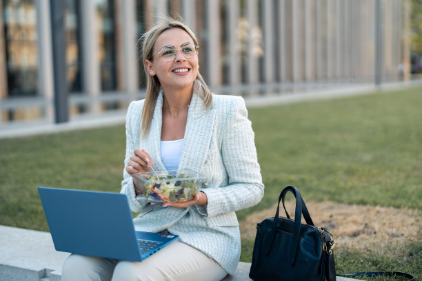 开朗的金发女商人，戴着眼镜，拿着沙拉图片下载
