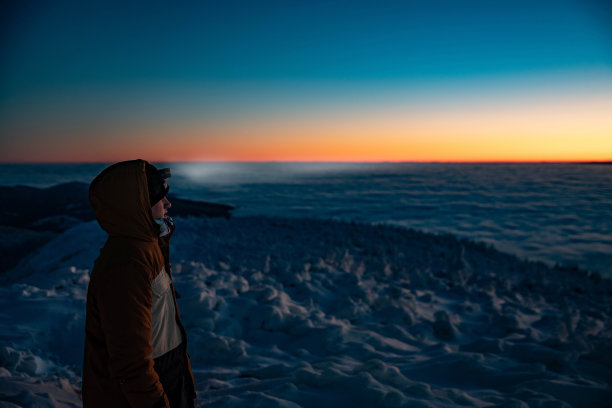 十几岁的男孩穿着一件暖和的冬季夹克，带着头灯走在冬天的山路上。图片下载