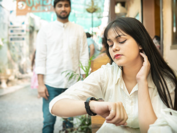 女朋友坐在那里等她的男朋友，他终于来约会了。图片下载