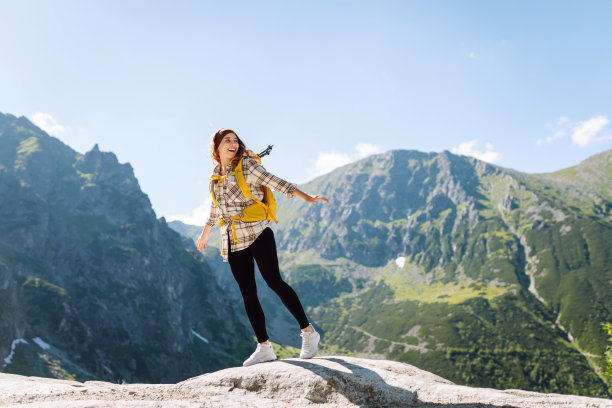 活跃的女人欣赏雄伟山脉的美景。图片下载